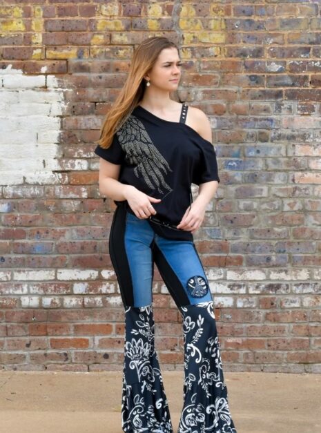 Model is wearing jeans with black and white floral print bell ruffle bottoms