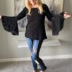 Model wearing black aline top with lace bell sleeves